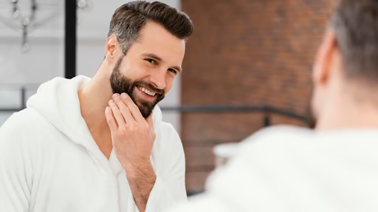 imagem de um homem feliz e confiante, exibindo uma barba bem cuidada e saudável, transmitindo a ideia de sucesso no combate à caspa na barba.